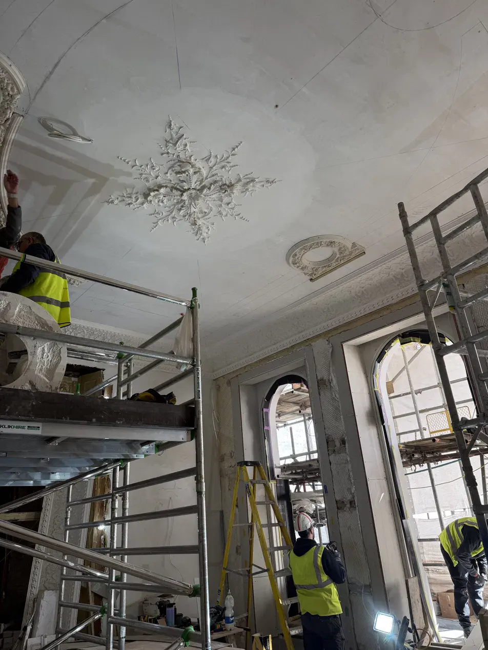 Ceiling rose and decorative cornice undergoing restoration from scaffold