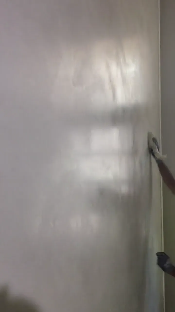 Microcement being trowelled onto a flat wall