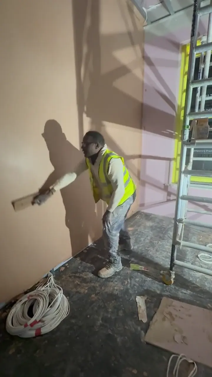 Choice Finishes plasterer skimming a tall wall at high level, London