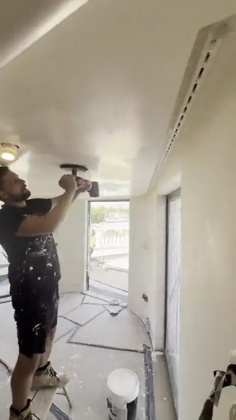 Plasterer burnishing a polished plaster ceiling to a high sheen at Lancaster Gate, London