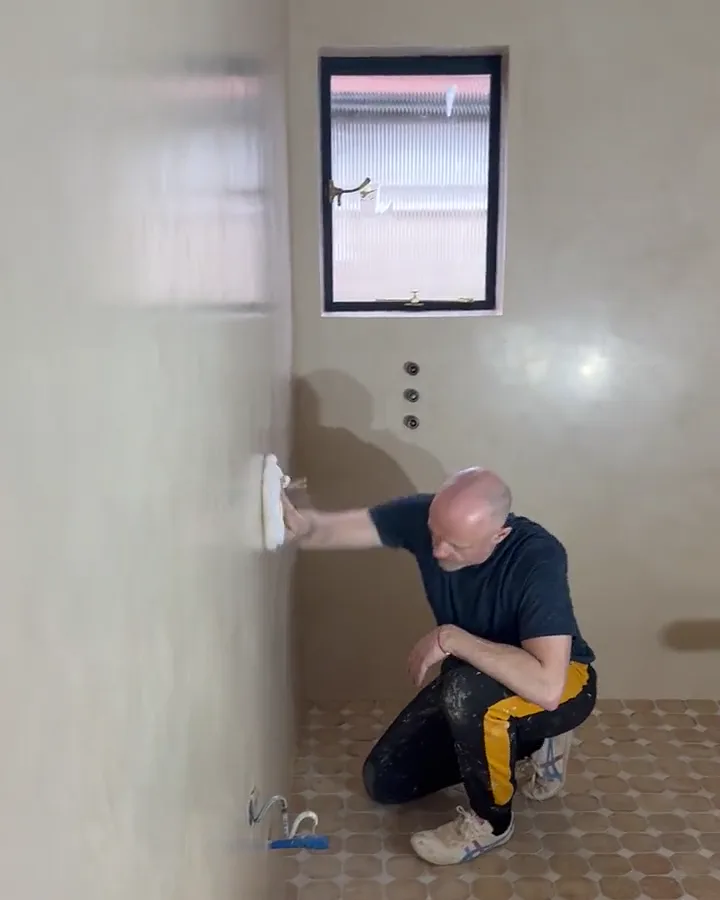Plasterer burnishing a tadelakt wall by hand with Moroccan olive soap